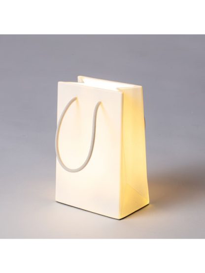 Seletti lampada Daily Glow Shopper, simpatica riproduzione di una busta regalo che si illumina con tre intensità di luce, vista trasversale accesa in modalità alta.