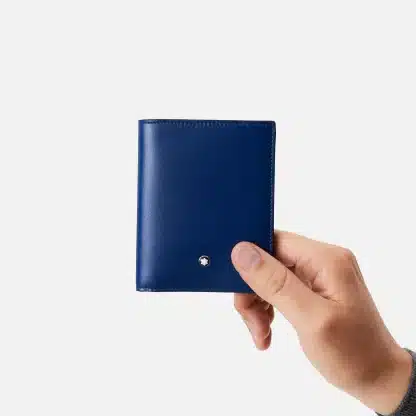 Portafoglio compatto Montblanc Meisterstück con sei aperture per carte di credito ed una tasca superiore per le banconote è realizzato in una nuova tipologia di pelle di vitello pieno fiore estremamente lucida nel colore Ink Blue. Visto in mano