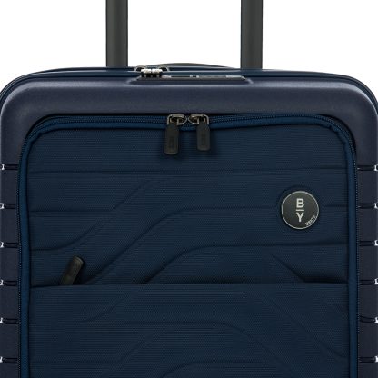 Bric's trolley b|y da cabina espandibile di colore blu con tasca anteriore dotata di scomparti porta pc e tablet, 8 ruote e chiusura TSA con combinazione, particolare del logo