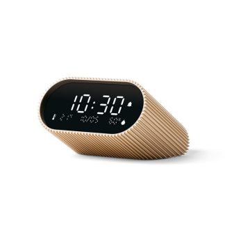 Lexon sveglia Ray Clock colore oro, dotata di uno schermo LCD VA puro nero per una visibilità chiara in ogni momento, sensori di temperatura ambiente e umidità, visualizza informazioni utili per il tuo benessere quotidiano, vista in diagonale appogiata.