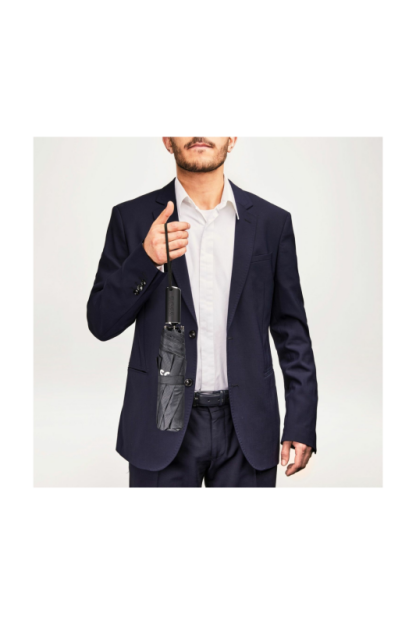 Hugo Boss ombrello tascabile Loop Black è un accessorio da viaggio pratico ed elegante. È progettato per essere facile da portare con te, grazie alle sue dimensioni compatte. Visto in mano al modello.